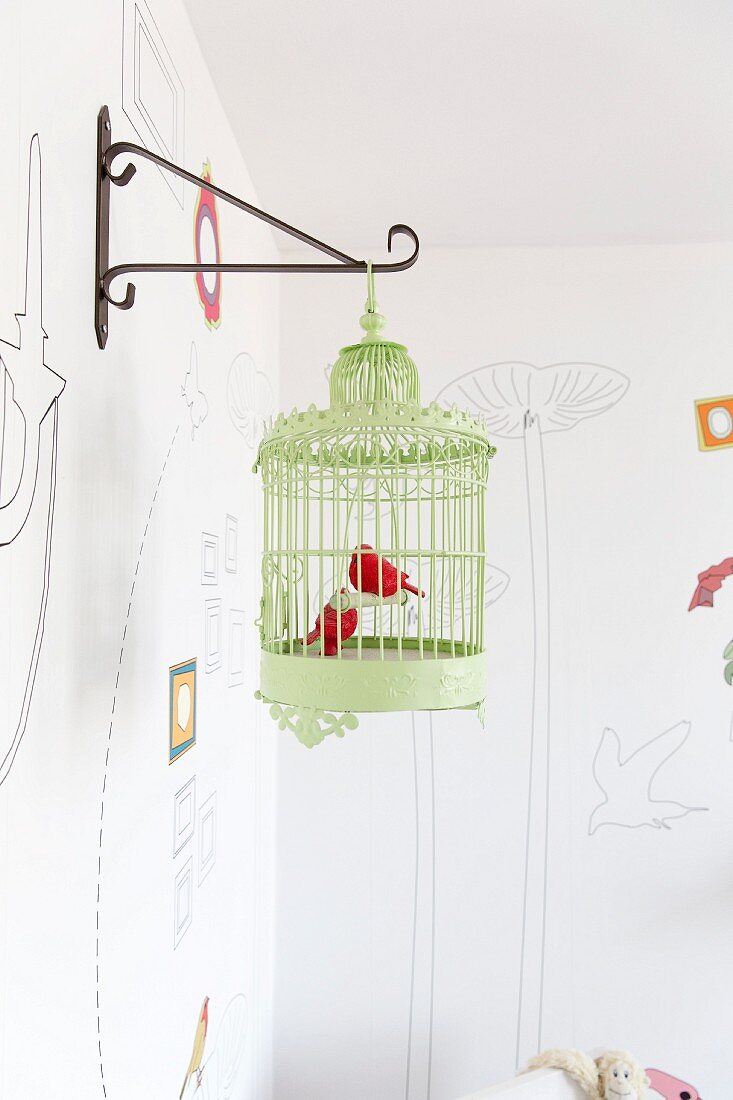 Grüner Vintage Vogelkäfig mit Dekovögel an Metall Wandkonsole aufgehängt