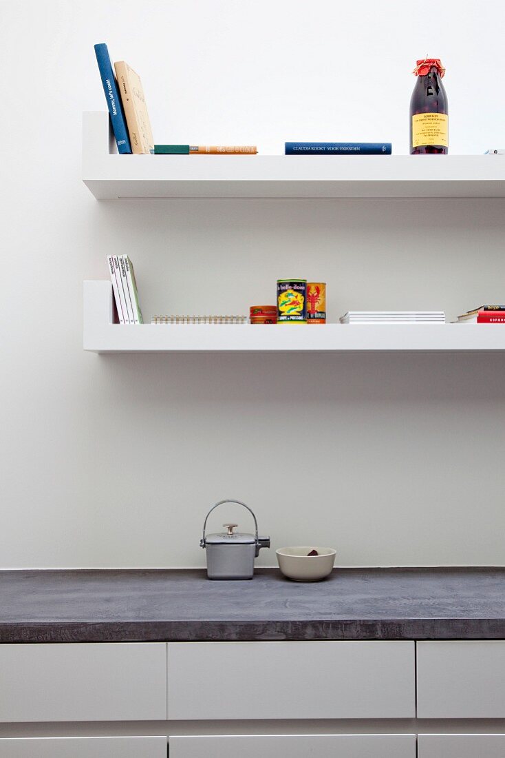 White, floating shelves above kitchen units with concrete worksurface