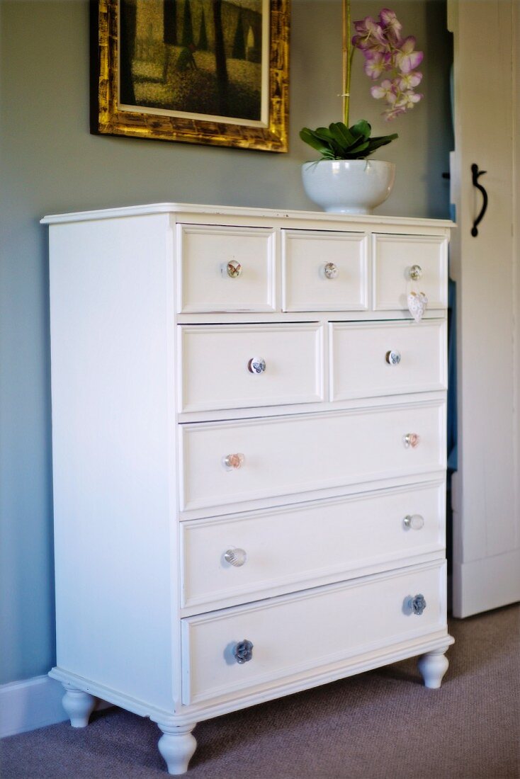 White-painted chest of drawers against grey-painted wall