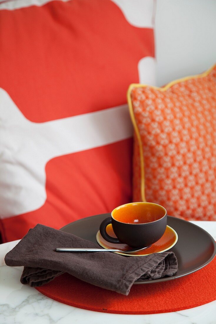 Brown and orange place setting with cup