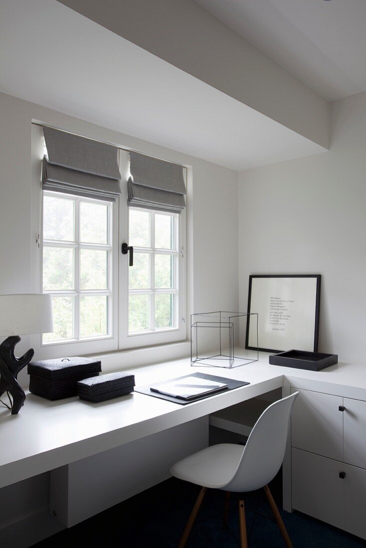 Arbeitsecke mit weisser Schalenstuhl im Klassikerstil vor eingebauter Arbeitsplatte am Fenster