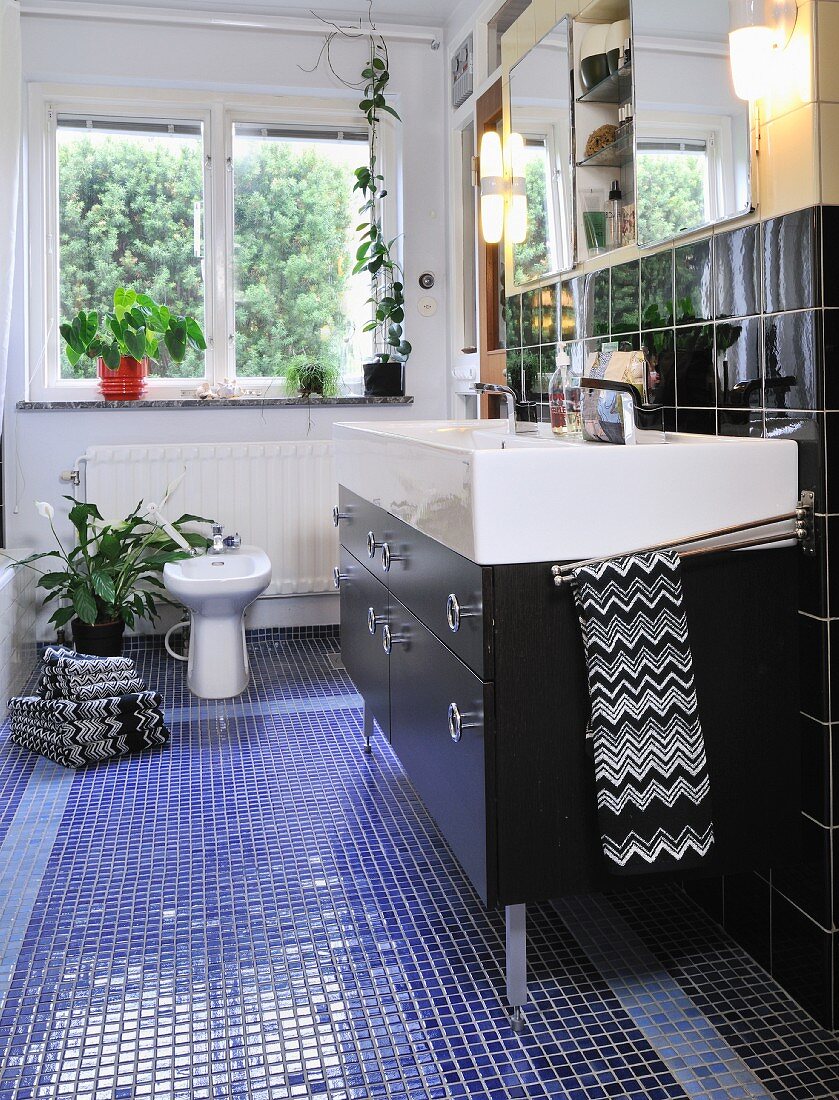 Waschtisch mit schwarzem Unterbau und eingebautem Spiegelschrank in schmalem Badezimmer mit Bidet