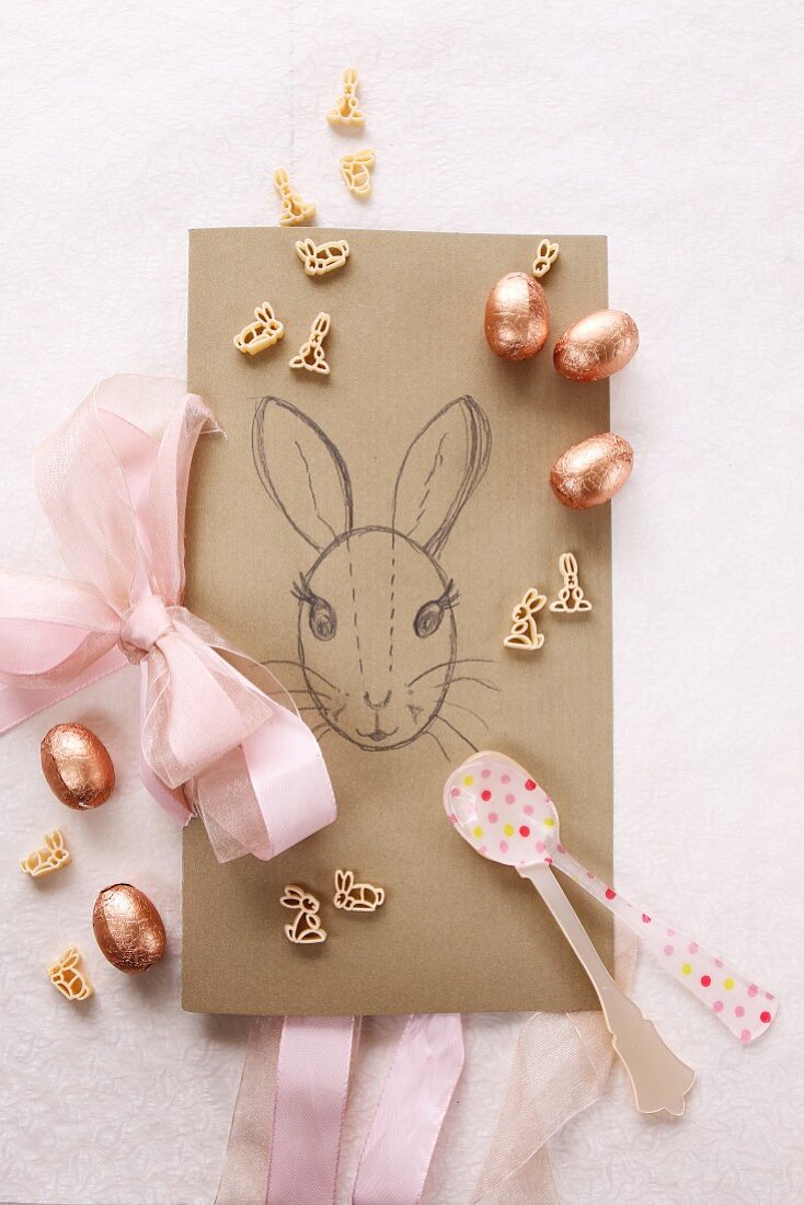 Handgezeichnete Karte mit Osterhase, Zuckereier und Nudeln in Form von Kaninchen