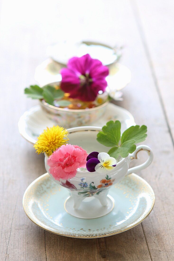 Three demitasse cups with various flowers