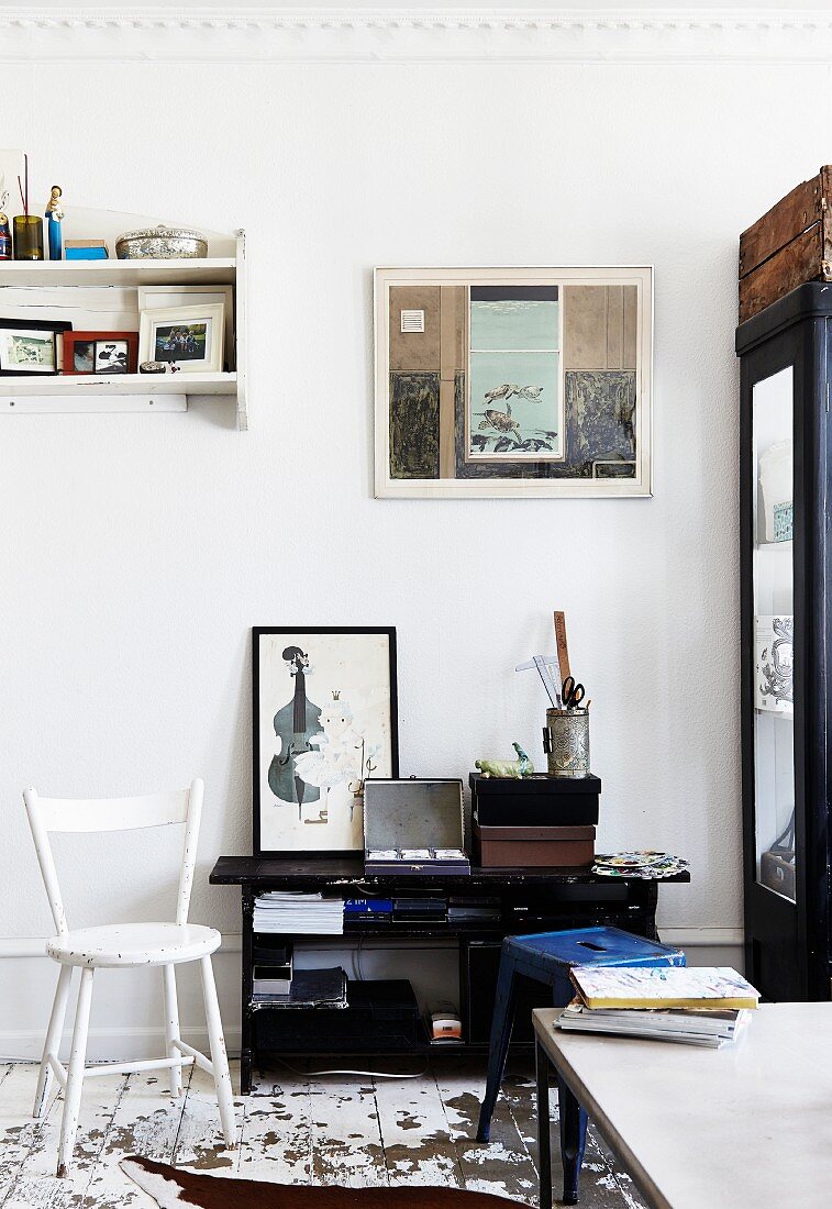 Weiß lackierter Holzstuhl und schwarzes Regal in Vintage Wohnraum