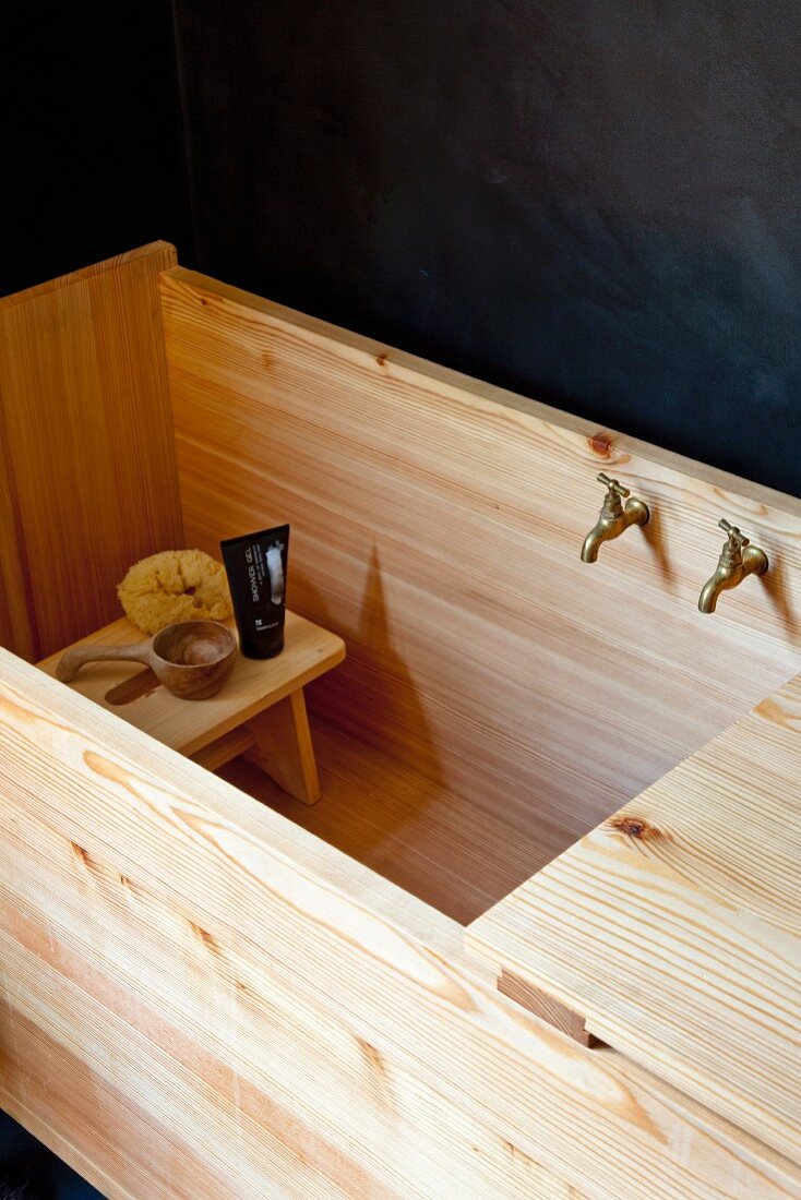 Bathing utensils on footstool in wooden, trough-style bathtub