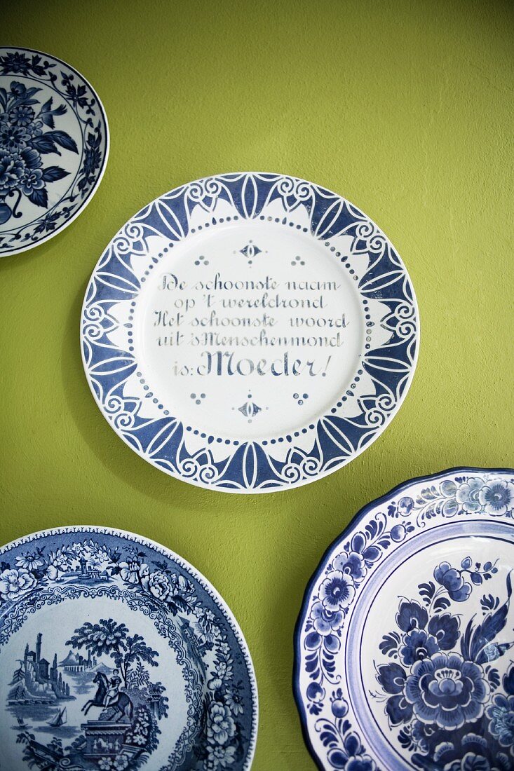 White and blue painted plates on green-painted wall