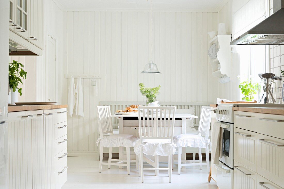 Blick von der zweizeiligen, skandinavischen Einbauküche auf Essplatz im weissen Shabby Stil