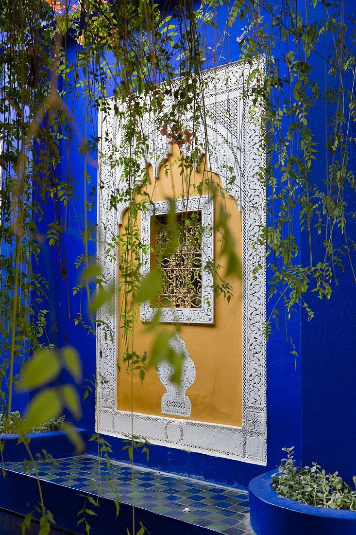 Jardin Majorelle in Marrakesch - mit Ornamenten reich verziertes Fenster, umgeben von einem eigens entwickelten, leuchtenden Blauton (Bleu Majorelle)