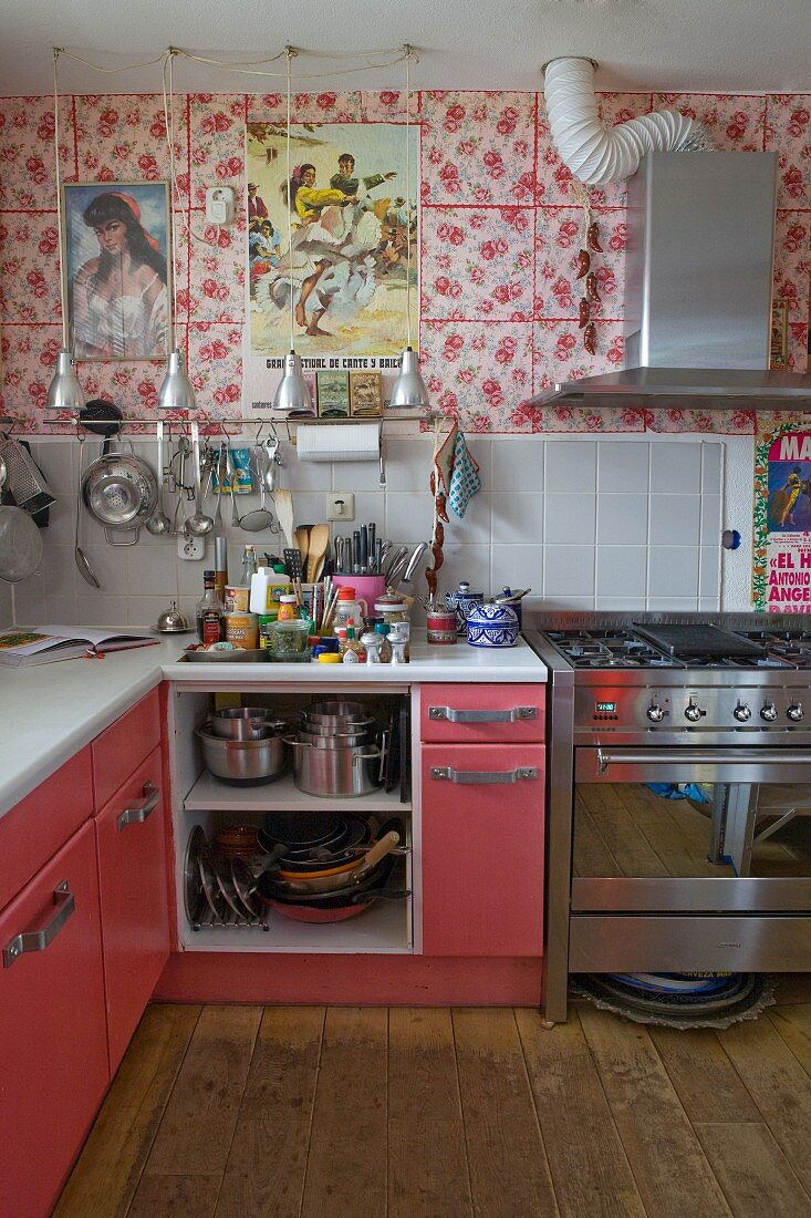 Eklektische Küche mit Blumenmuster, spanischen Plakaten und rosa gestrichenen Küchenfronten