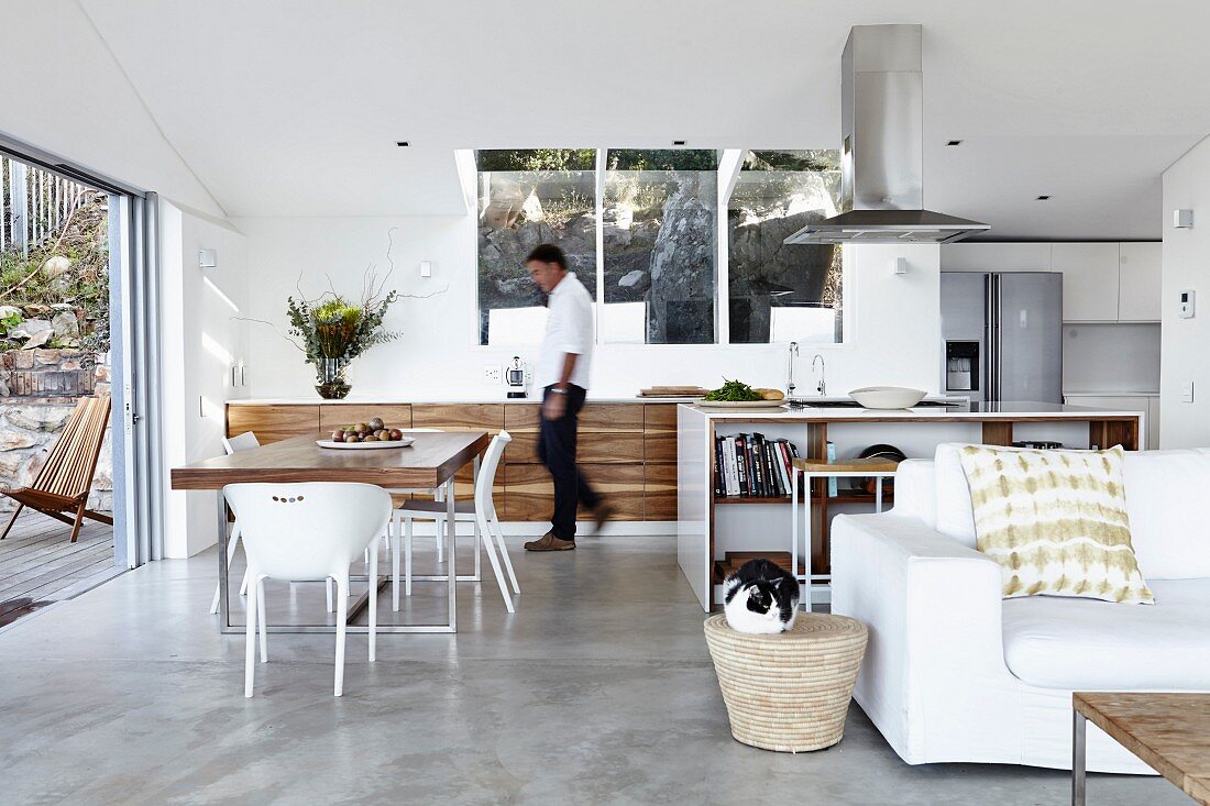 Designerküche mit Essplatz in offenem Wohnraum, im Vordergrund weiße Couch