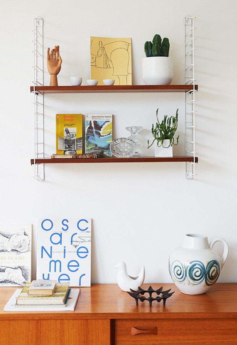 'String' shelves on wall above retro ornaments on partially visible sideboard