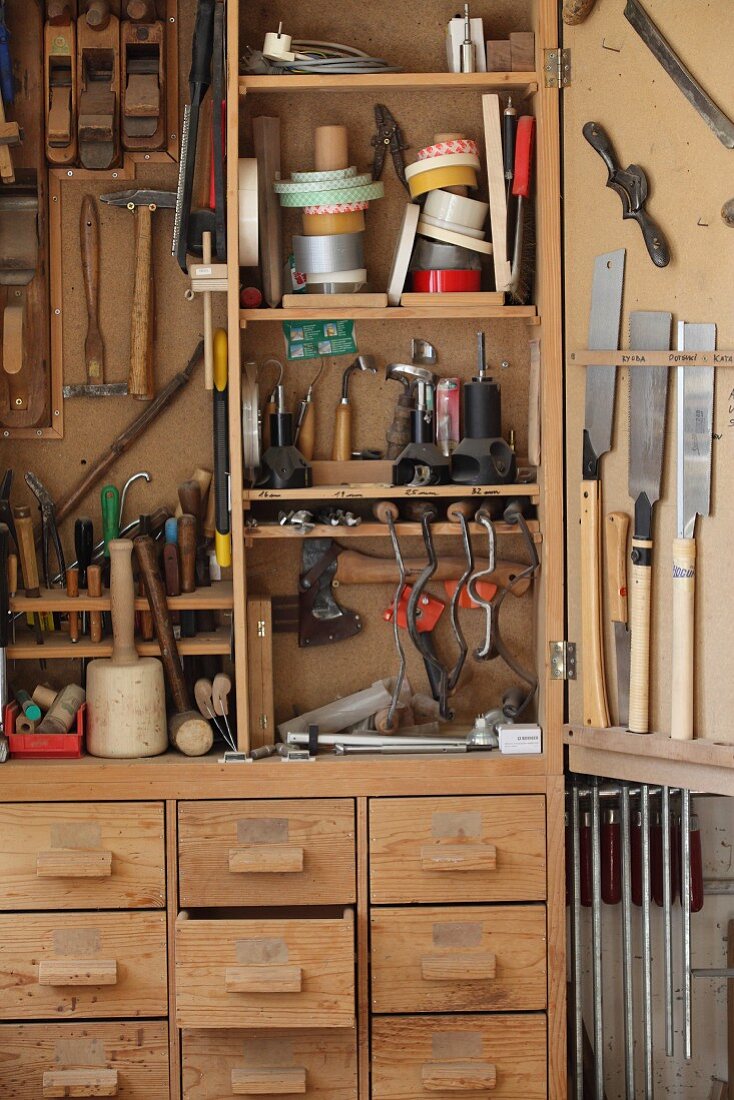 Hand tools in traditional tool cabinet in carpenter's workshop