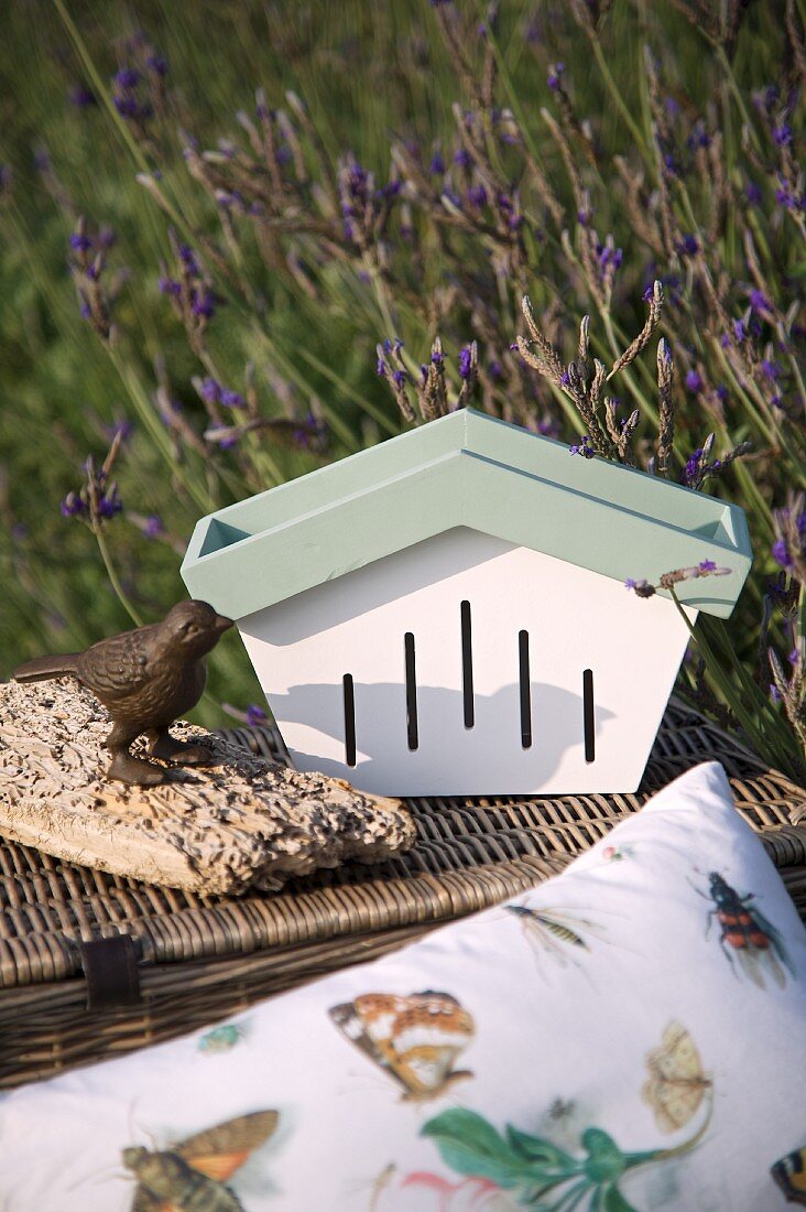 Butterfly box, bird ornament and picnic basket outdoors