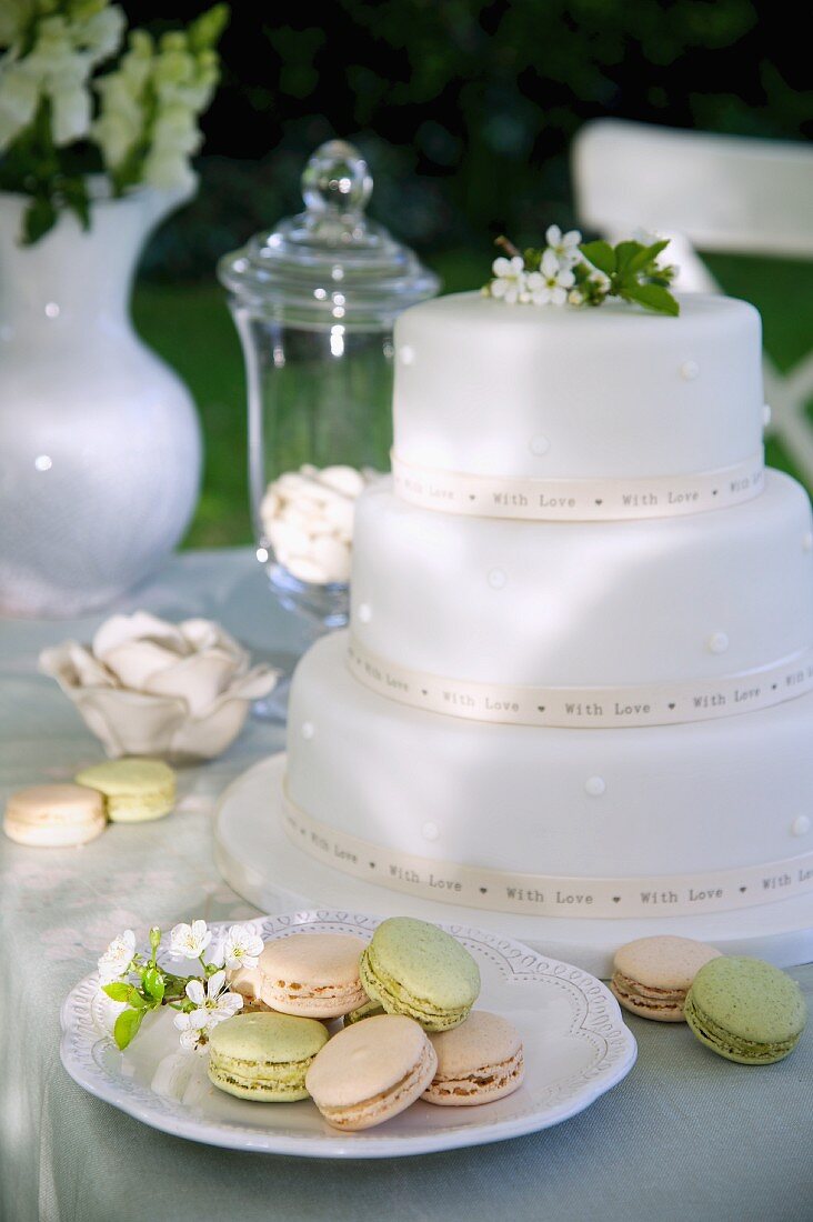 weiße, mehrstöckige Hochzeitstorte und Macarons