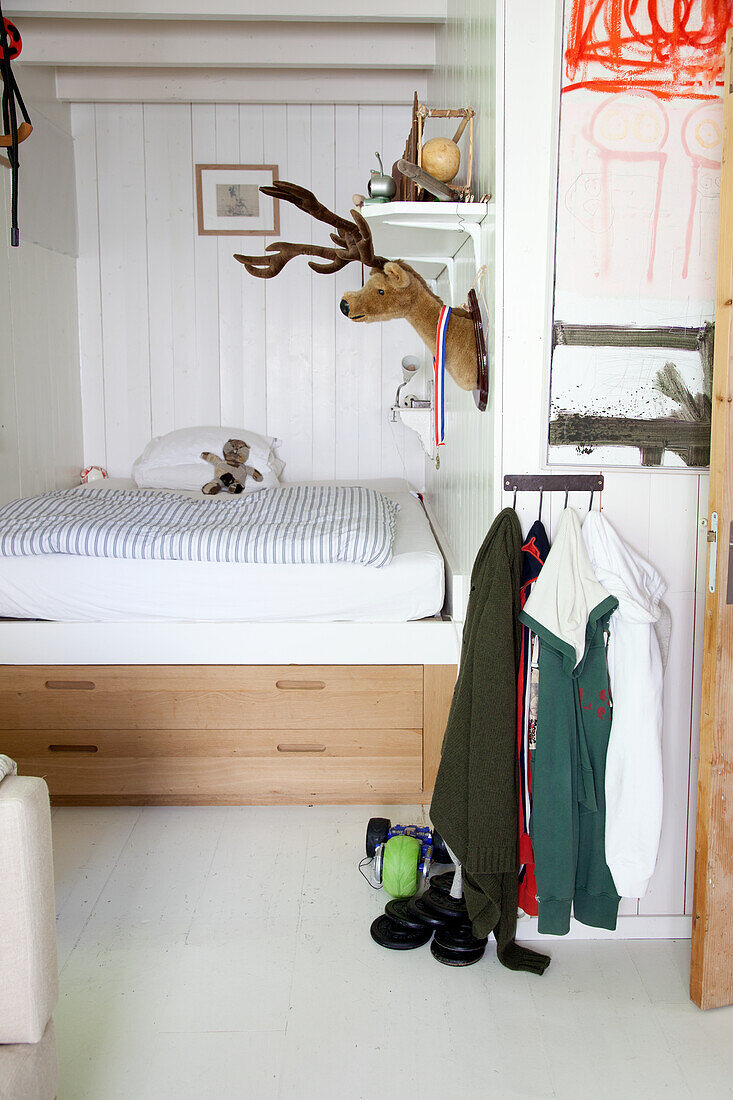 Boys' bedroom with white wood paneling and plush reindeer head