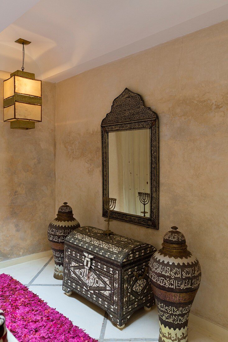 Haus des deutschen Künstlers Hinrich Sickenberger in der Medina, Marrakesch, Marokko, Wandspiegel und verzierte Truhe im überdachten Innenhof