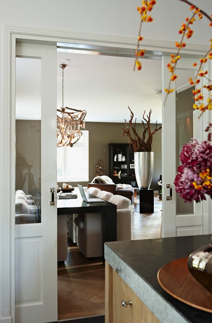 View past partially visible bouquet on counter to sliding doors opening into modern interior