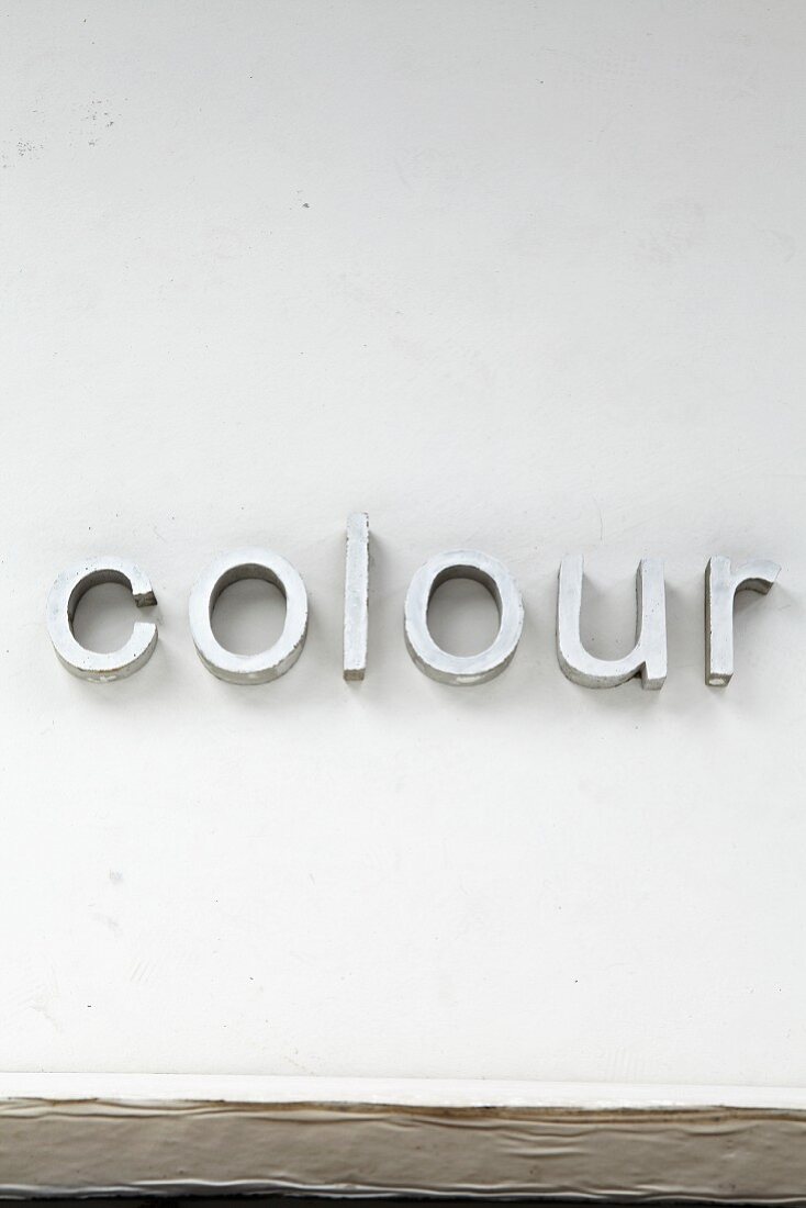 Deko-Buchstaben 'colour' an Wand