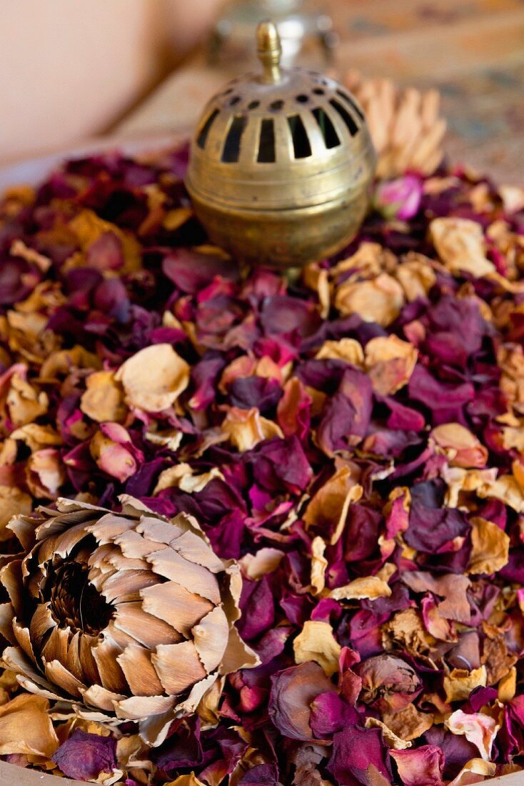 Dried rose petals with an incense burner