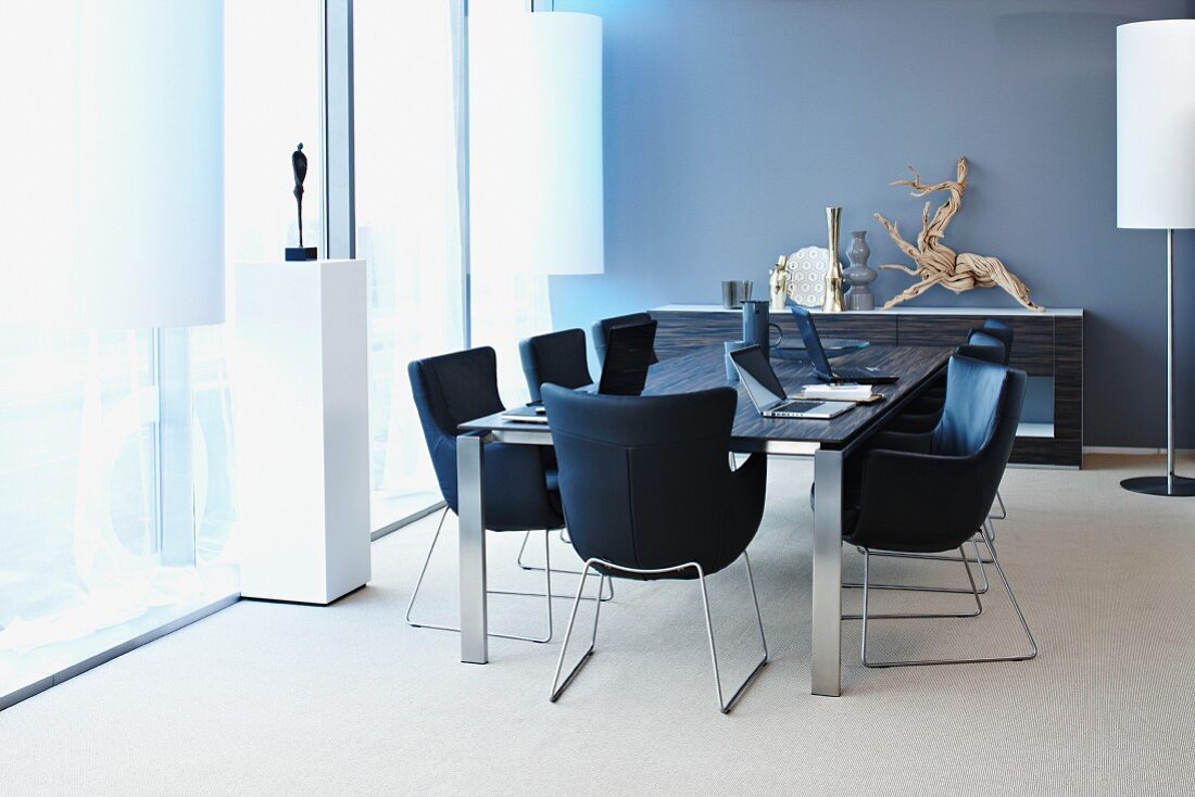 Black armchairs with metal frames around table in contemporary conference room