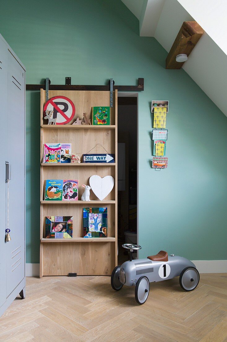 Sliding door with integrated shelves in child's attic bedroom