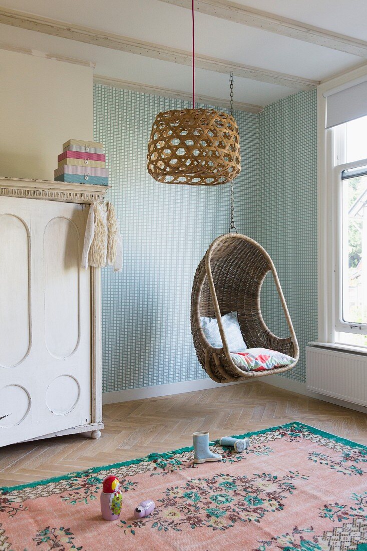 Wicker hanging basket and lampshades in child's bedroom