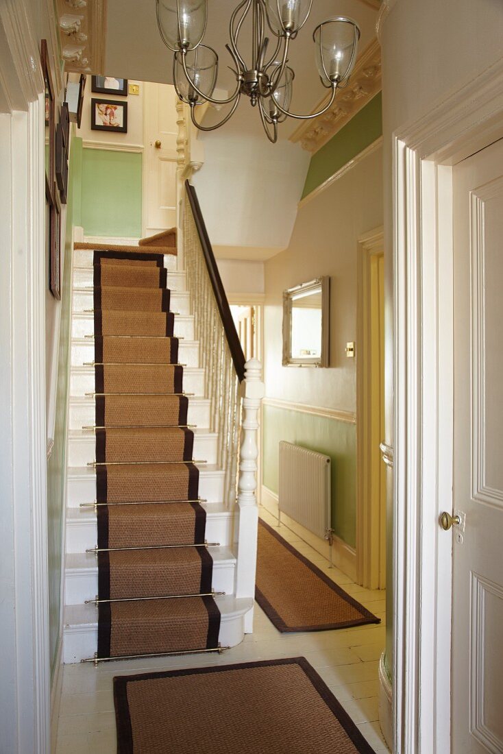 Treppe mit Teppichläufer und traditionelle Dielenflucht in englischem Wohnhaus
