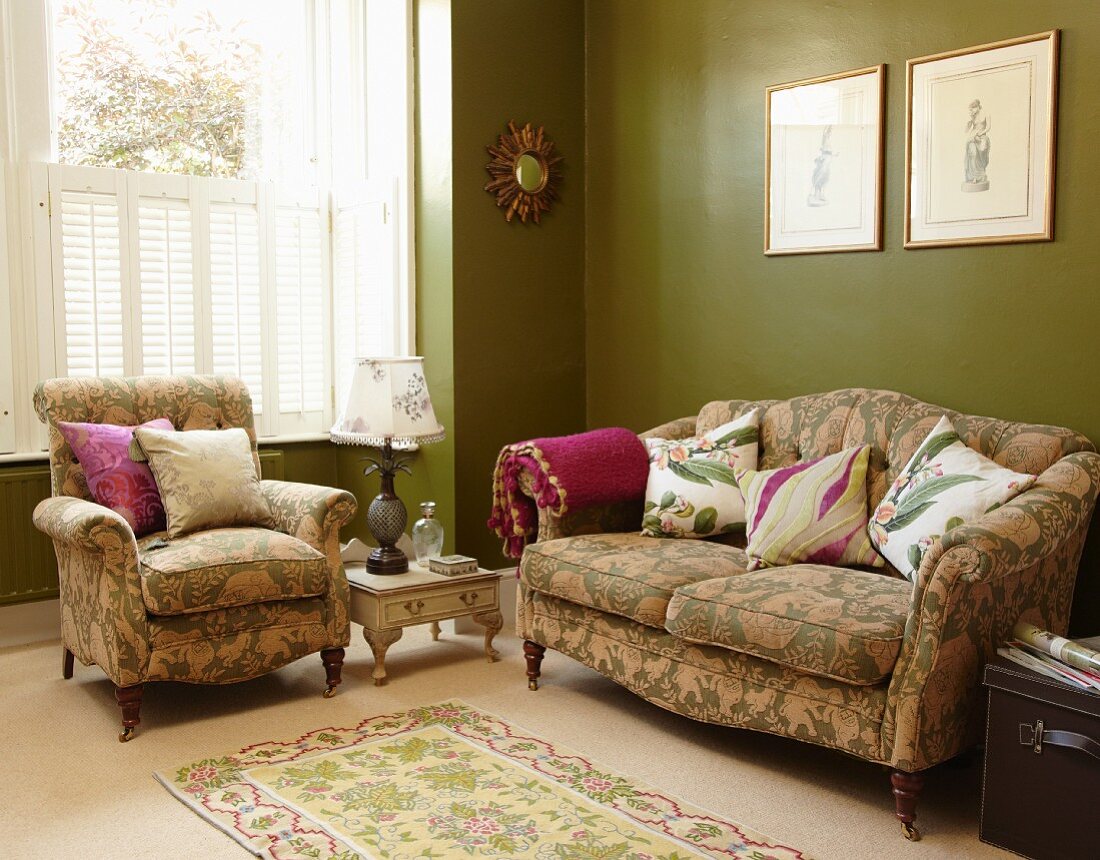 Green patterned sofa set with scatter cushions against green walls