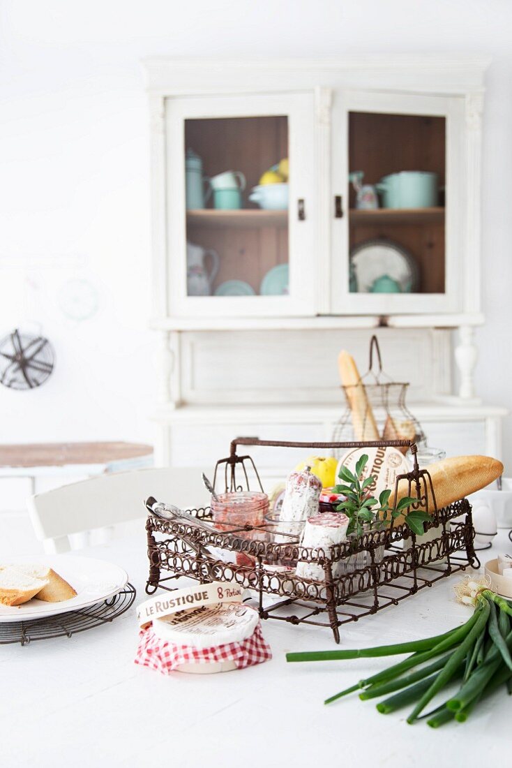 Country-house-style kitchen with groceries and utensils in vintage wire basket