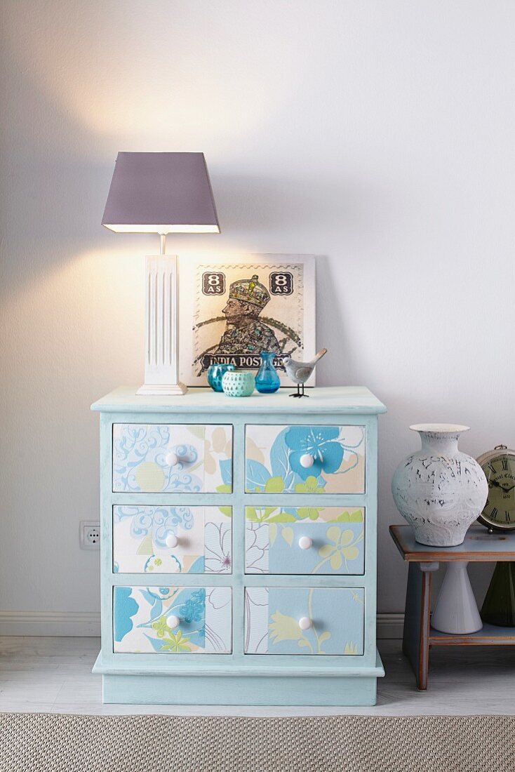 Old chest of drawers rejuvenated with pastel-blue paint and wallpaper