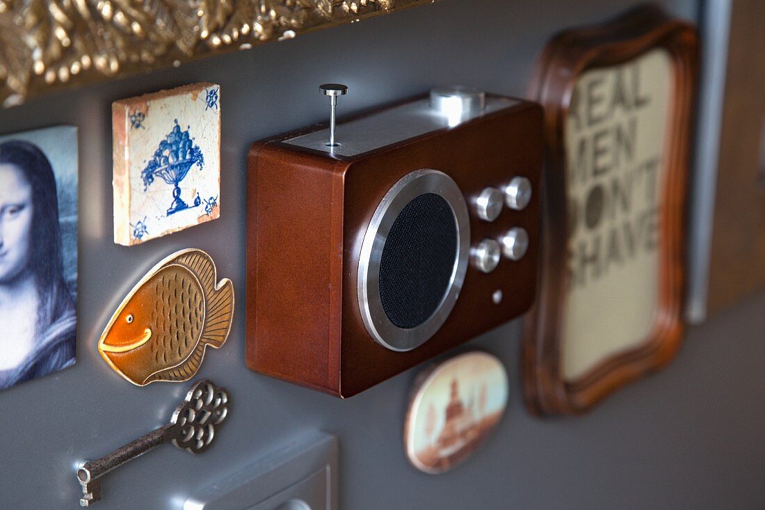 Souvenirs and mementoes (radio, key, tile) mounted on grey wall