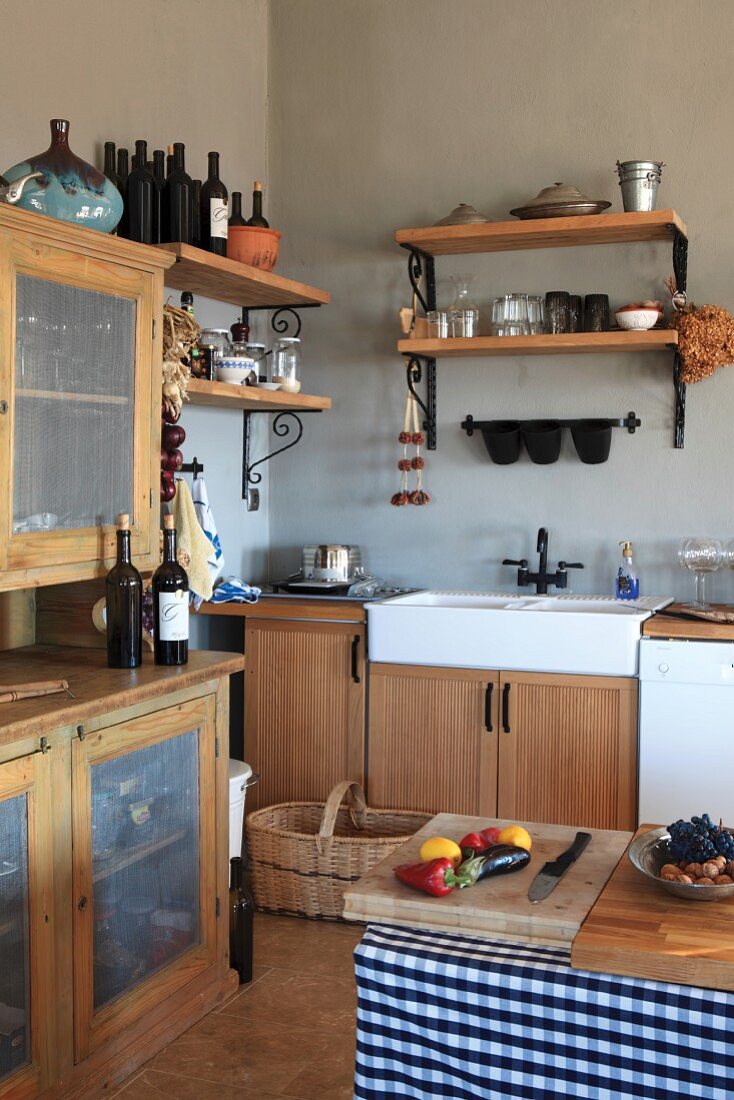 Rustikale Küche mit hellen Holzmöbeln, Spülbecken und Wandregalen