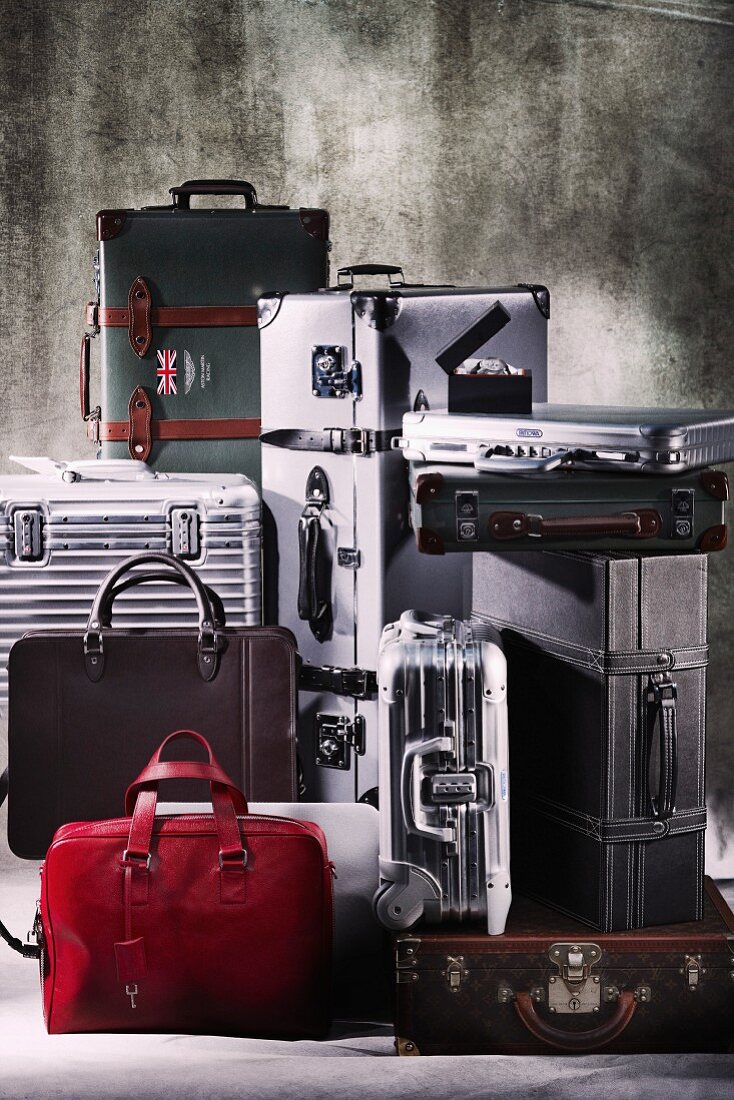 Various suitcases and bags arranged against grey background