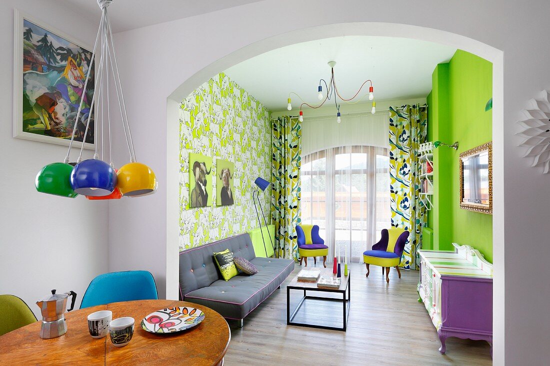 Farbenfroher Wohnbereich mit neongrüner Wand und Mustertapete im Retro-Ambiente