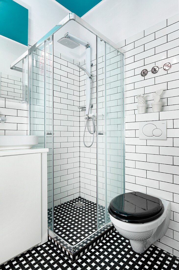 Zeitgenössisches Bad mit Dusche und Toilette in schwarz-weißem Farbkonzept