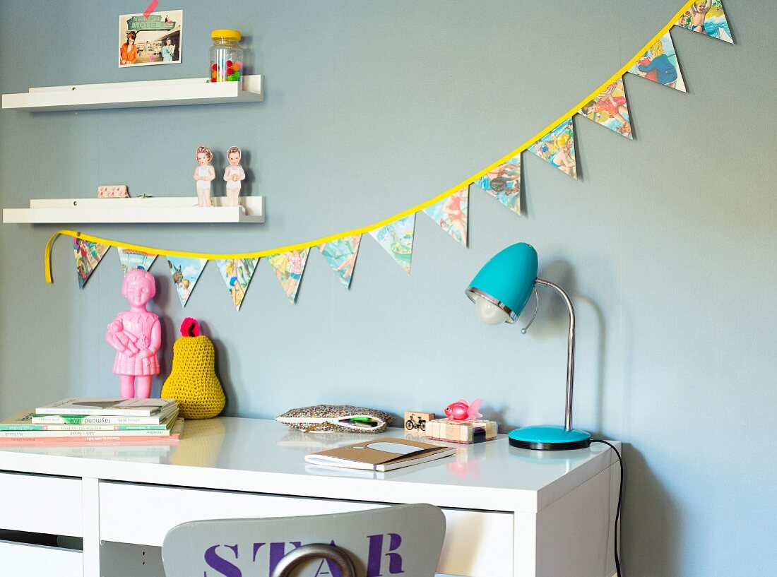 Selbstgenähte bunte Wimpelkette über Schreibtisch im Kinderzimmer