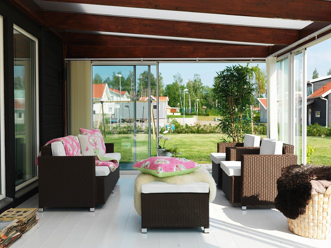 Conservatory with open sliding doors and rattan outdoor furniture