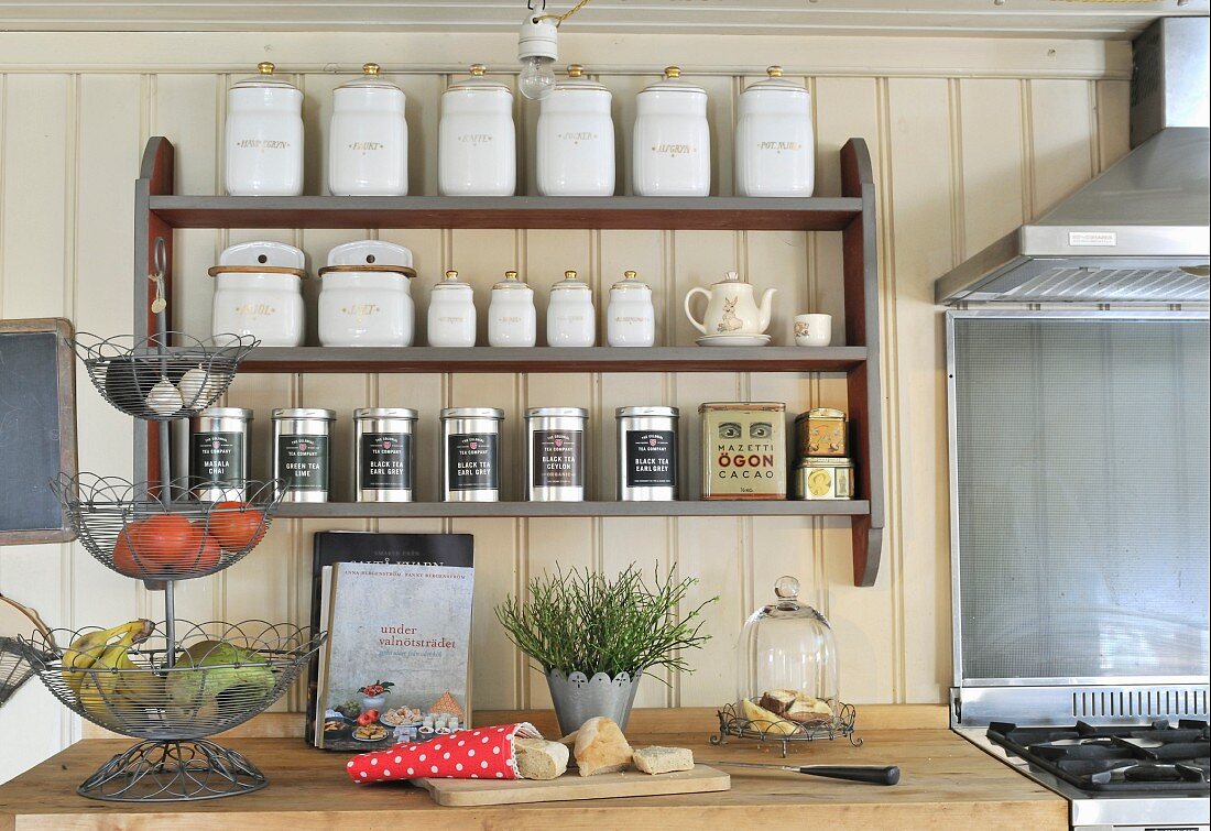 Retro storage jars in spice rack on cream wooden wall