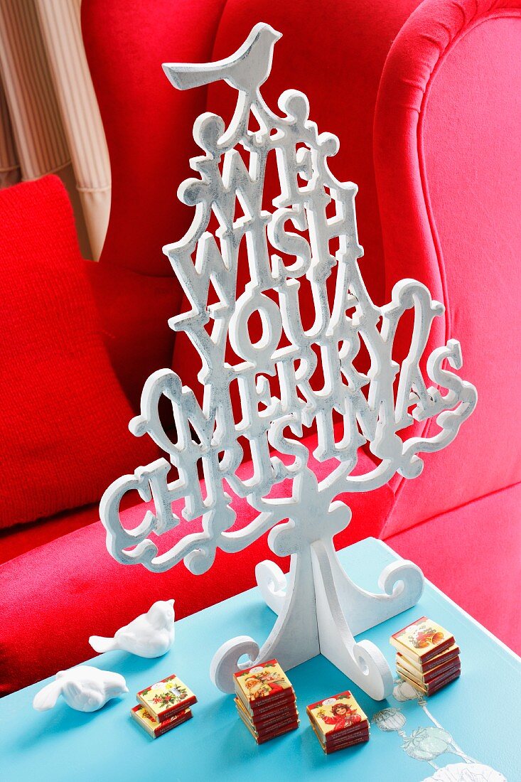 Stilisierter Weihnachtsbaum aus Buchstaben, darunter kleine Schokoladentäfelchen
