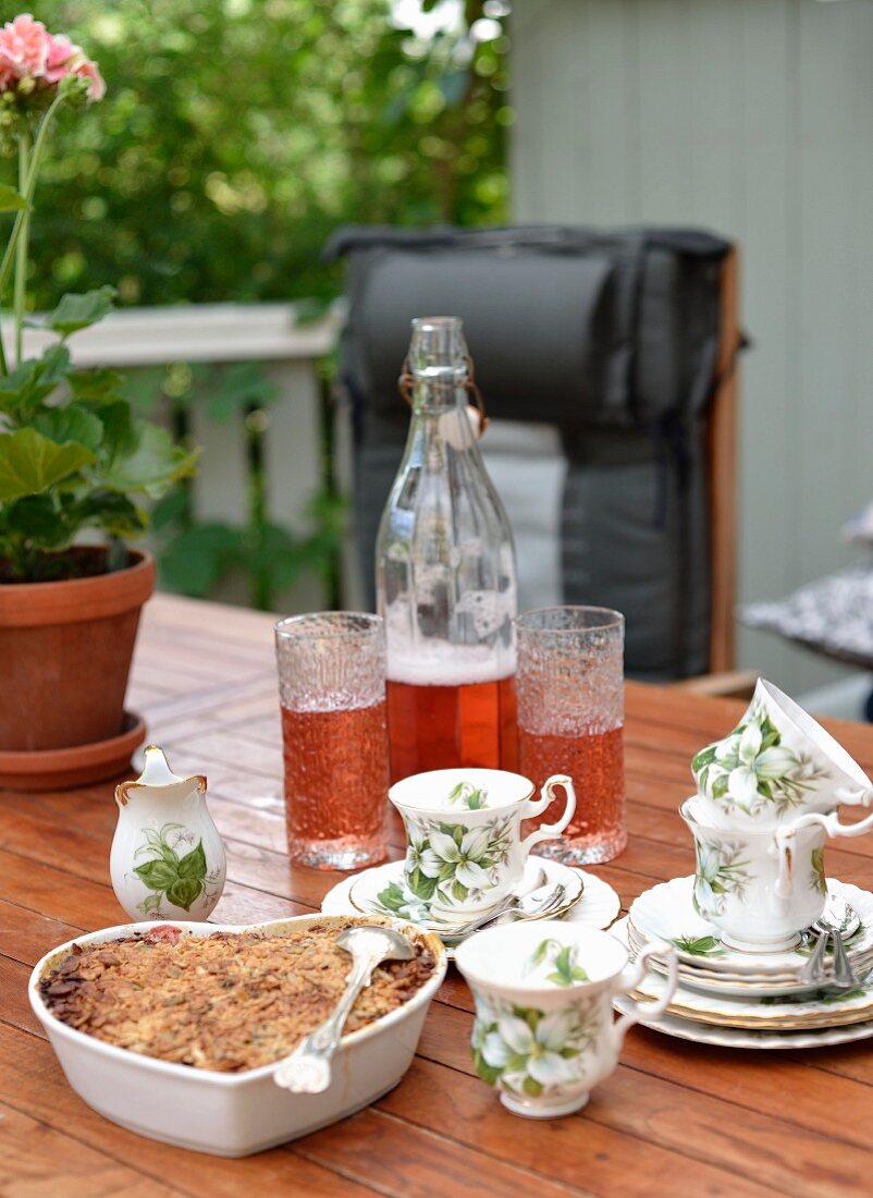 Heart-shaped fruit pie and drinks on garden table
