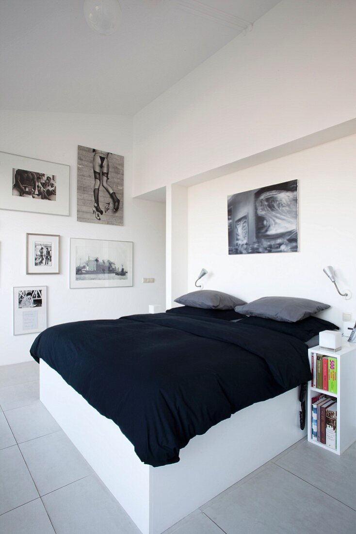 Doppelbett mit weißem Untergestell und schwarze Tagesdecke in modernem Schlafzimmer