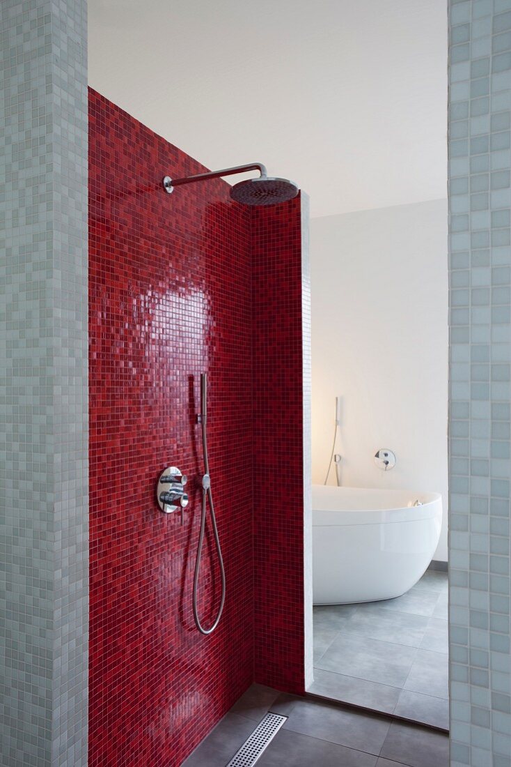 Duschbereich mit roten Mosaikfliesen, Blick durch Öffnung auf Badewanne