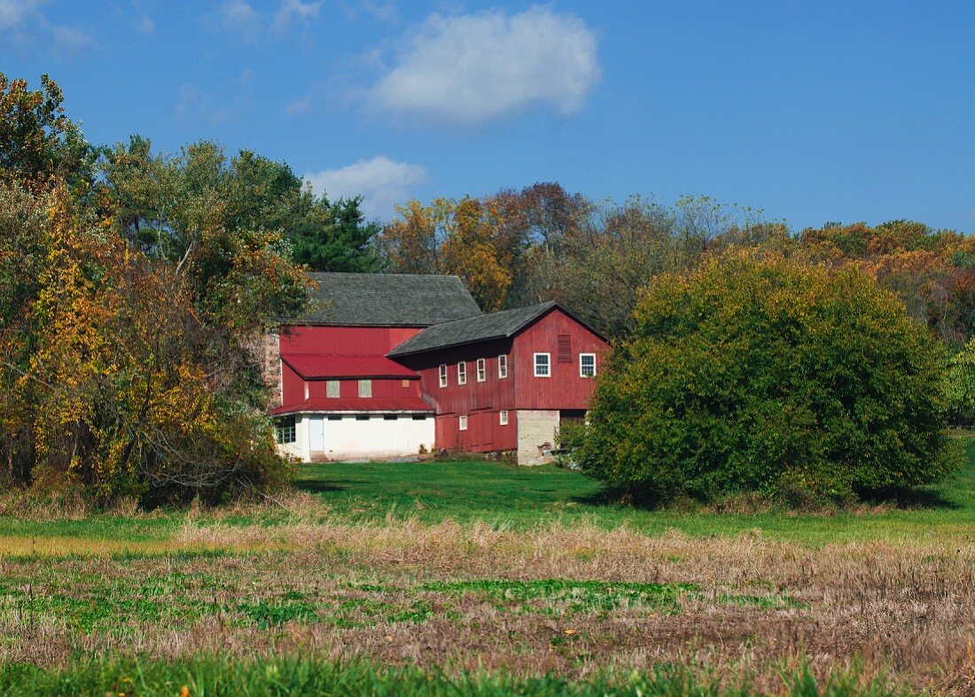 Grosses Bauernhaus in herbstlicher Landschaft