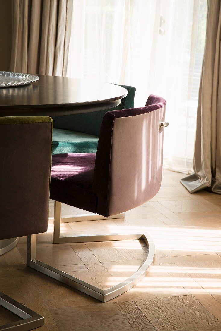 Upholstered cantilever chairs around table on parquet floor