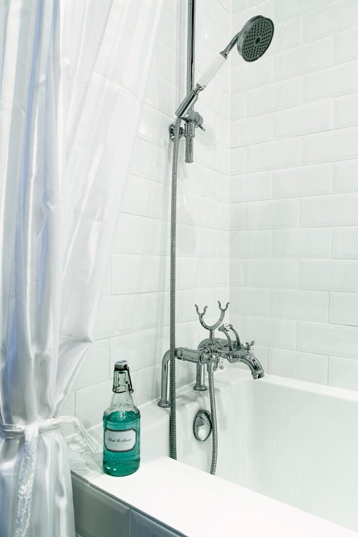 Bathtub with vintage tap fittings and swing-top bottle on rim