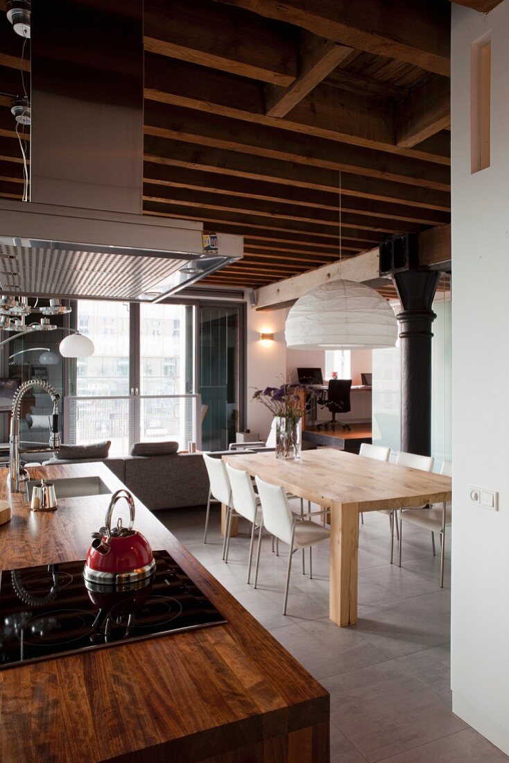 Kücheninsel mit rustikaler Holz Arbeitsplatte und Dunstabzug, moderner Essplatz unter Papier- Pendelleuchte