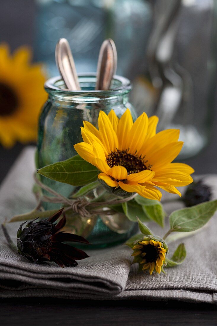 Glas für Besteck dekoriert mit Sonnenblumenblüte