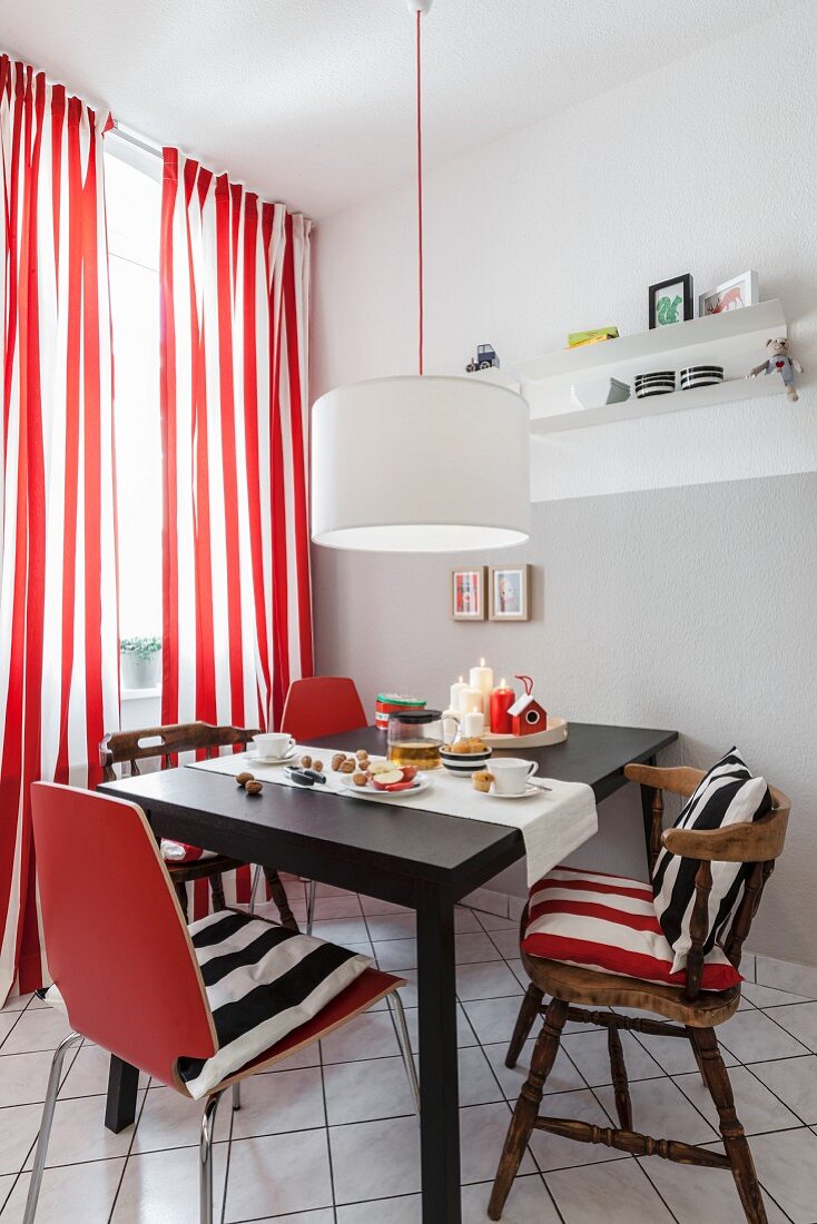 Essplatz mit alten und neuen Stühlen vor Fenster mit rot-weiss gestreiften Vorhängen in renovierter Küche