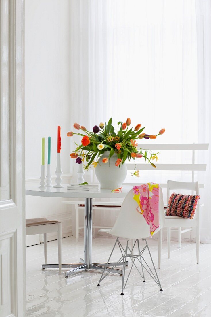 Üppiger bunter Tulpenstrauss auf Esstisch in weisser Ambiente